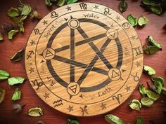 a wooden plate with an inverted pentagram surrounded by leaves and other things around it