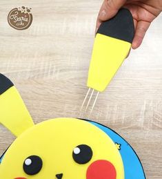 someone is decorating a pikachu cake with icing