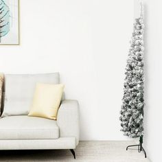 a white couch sitting next to a christmas tree