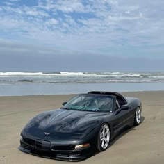 a black sports car parked on the beach