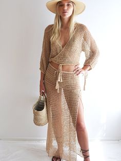 a woman in a straw hat and dress posing for the camera with her hands on her hips