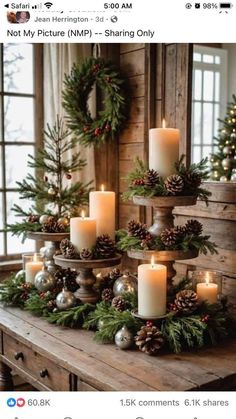 a table topped with lots of candles next to christmas wreaths and pineconis