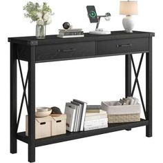 a black console table with two drawers and a lamp on the top, in front of a white background