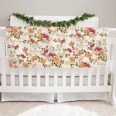 a white crib with floral bedding and greenery