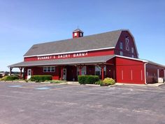 an empty parking lot with a red barn