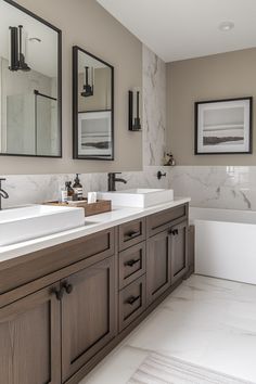 a large bathroom with two sinks and mirrors on the wall next to it's bathtub