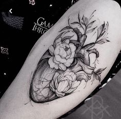 a black and white photo of a woman's arm with flowers on it,