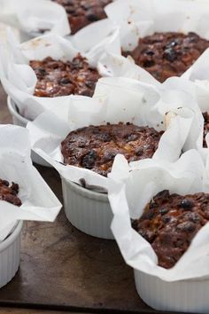 several muffins in white paper cups on a table