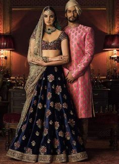 This Deep Blue Color Wedding lehenga is in silk velvet embroidered with thread and zardozi work. Dupatta is in gold color net fabric with embroidered edges and sequins butties inside. Blouse is also fully embroidered. Velvet Sabyasachi, Red Sherwani, Gold Dupatta, Navy Blue Lehenga, Bohemian Style Gown, Coordinated Outfits, Sabyasachi Bridal, Types Of Gowns, Salmon Red