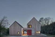 the house is made out of wood and has two red doors on each side of it