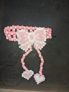 a pink and white beaded cat on a black surface