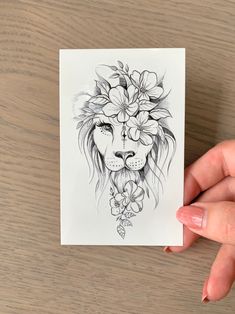 a drawing of a lion with flowers on its head is being held by a woman's hand