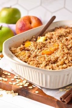 an oatmeal dish with apples and cinnamon sticks on the table next to it