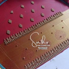 a close up of a red and gold table cloth with beaded designs on it