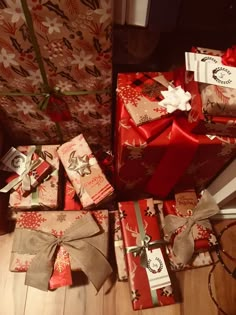 a pile of wrapped presents sitting on top of a wooden floor