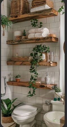 the bathroom is decorated in white and has wooden shelves with plants on top of them