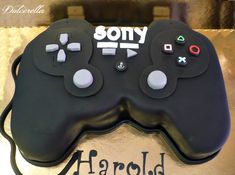 a close up of a cake with a controller on it's side and the words sony