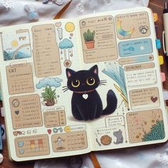 a black cat is sitting on top of an open notebook with stickers and markers