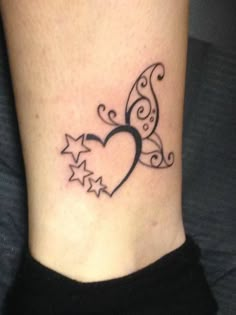 a small tattoo on the ankle of a woman's foot with stars in the shape of a heart