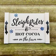 a sign that says sleigh rides and hot cocoa on the farm with snowflakes