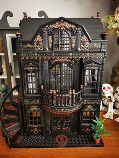 a black doll house with lots of windows and balconies on top of it