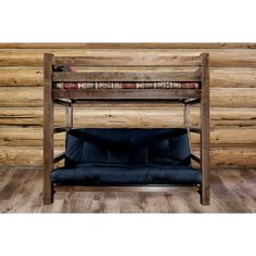 a bunk bed with futon underneath it in front of a log cabin style wall