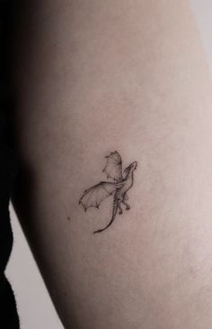 a small dragon tattoo on the right side of the thigh, it is black and white