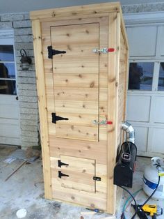 a large wooden door sitting in the middle of a garage next to a hose box