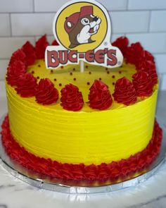 a yellow cake with red frosting and a sticker that says ducects