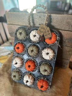 an assortment of crocheted pumpkins are displayed in a display case on a table