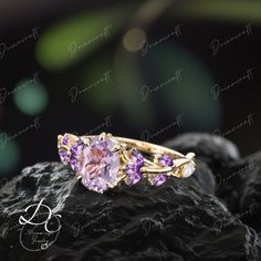 a pink and purple ring sitting on top of a rock