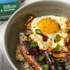 a bowl filled with rice, meat and an egg on top of it next to a carton of milk