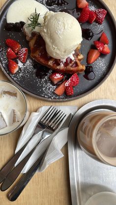 a plate topped with waffles, strawberries and ice cream