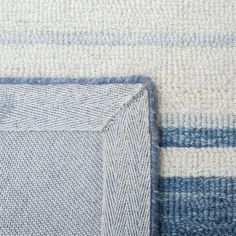 a close up view of a blue and white rug with an area that has been made out of yarn