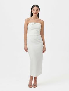 Introducing the Barbi Bow Midi Dress, a delightful blend of sophistication and charm. With its strapless design and pencil shape midi skirt, this dress becomes classic elegance and timeless. The bow front detail adds a playful and feminine touch, enhancing its overall appeal. Features a discreet zip on the back, strapless neckline and midi lenght. Chic Strapless Dress With Bow For Formal Events, Chic Bandeau Dress For Brunch, Elegant Strapless Dress For Brunch, Elegant Strapless Dress With Bow For Formal Occasions, Elegant Strapless Mini Dress For Brunch, Chic Strapless Bandeau Dress For Brunch, Elegant Bandeau Strapless Dress For Brunch, Chic Knee-length Strapless Dress For Formal Occasions, Chic White Strapless Dress For Formal Occasions