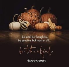 a group of pumpkins sitting on top of a wooden table with a quote above it