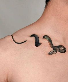 a man with a tattoo on his back that has two snakes crawling around the neck