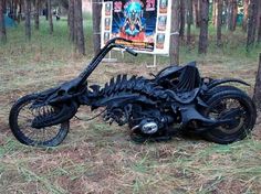 a motorcycle that is laying on the ground in the grass near some trees and signs