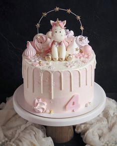 a pink cake with white frosting and decorations