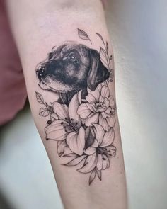 a black and white photo of a dog's head on the arm with flowers around it