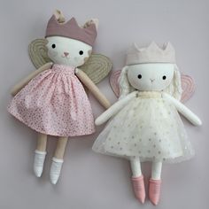 two stuffed animals wearing dresses and hats