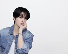 a woman with short black hair wearing a denim jacket and white t - shirt is posing for the camera