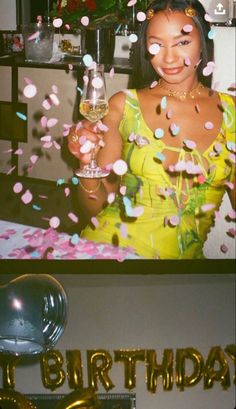 a woman holding a wine glass in front of her face and confetti on the table