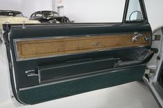 the interior of an old car with wood trim and door panels on display in a showroom