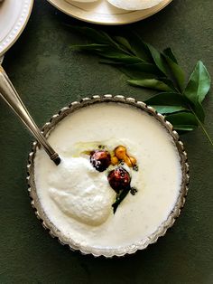 a bowl filled with cream and fruit on top of a table