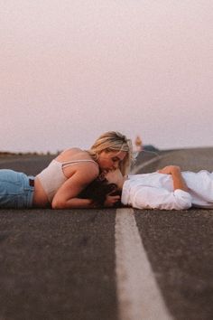 a man and woman laying on the road