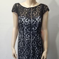 a mannequin wearing a black and white lace dress