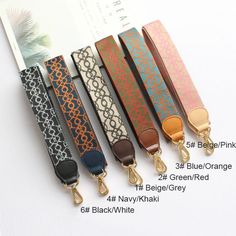 four different colored lanyards are lined up on a white surface with a book in the background