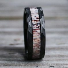 a black and white wedding ring with wood inlays on the inside of it