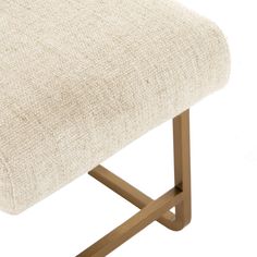 an upholstered chair with wooden legs and a beige fabric seat cover on it